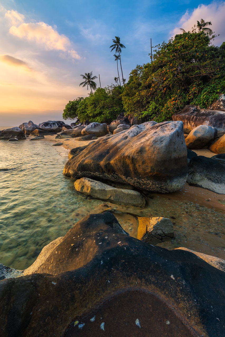 Des rochers à la plage sur l'île de Tioman brillent dans la chaude lumière du soir